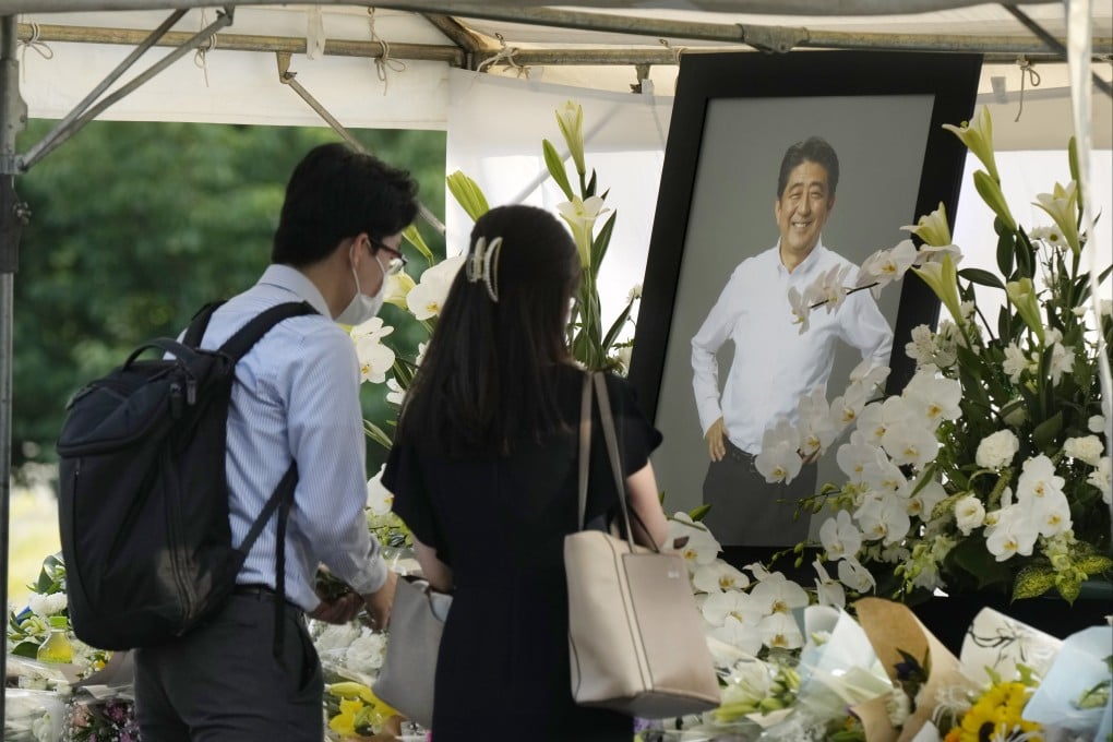 People leave floral tributes for former Japanese prime minister Shinzo Abe at Zojoji Temple in Tokyo on Monday. Photo: EPA-EFE