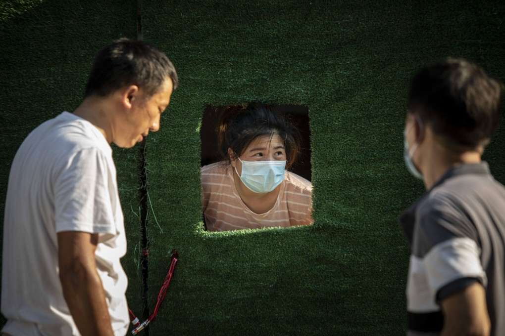 A resident peeks through an opening in the barricade surrounding a neighborhood placed under Covid-19 lockdown in Shanghai, July 10, 2022. Photo: Bloomberg