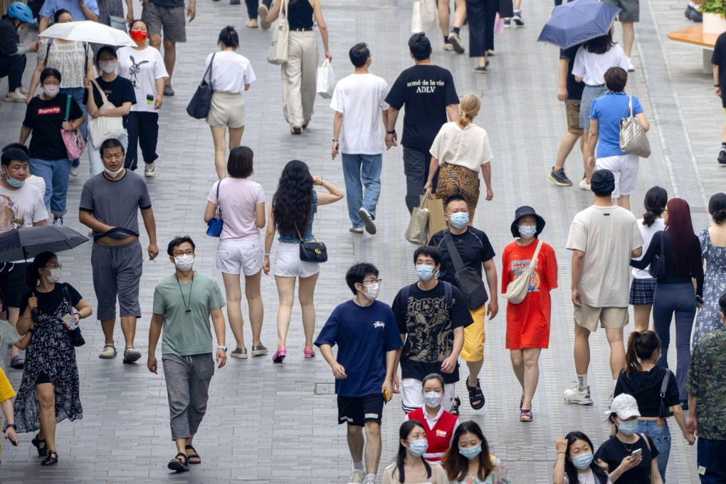 People wearing face masks walk along a pedestrian shopping street in Beijing on July 2, 2022. Photo: AP Photo