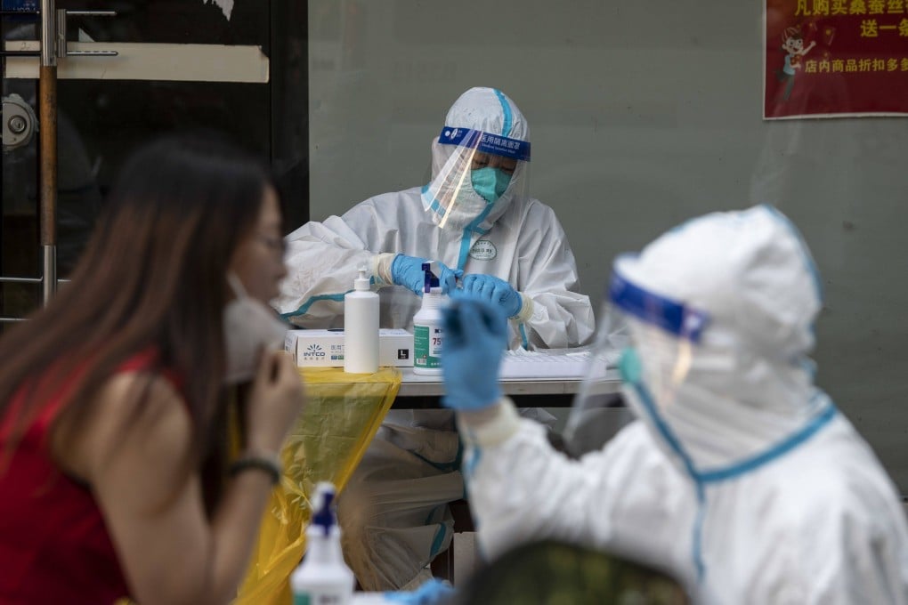Healthcare workers in protective gear give residents Covid-19 tests in Shanghai, July 10, 2022. Photo: Bloomberg
