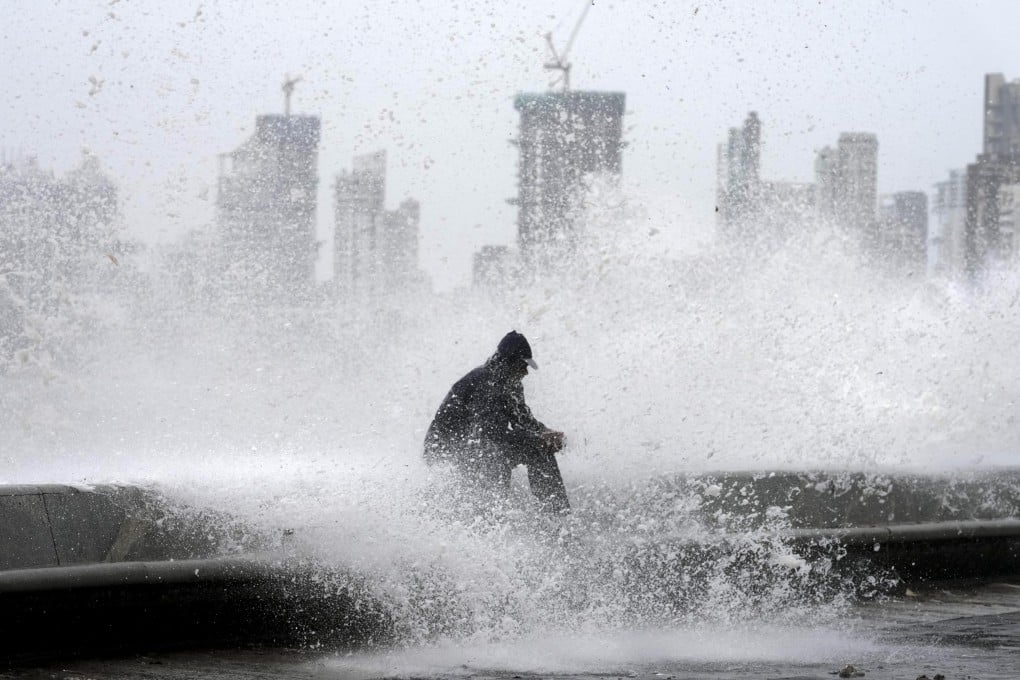 A man enjoys high tide waves during monsoon rains in Mumbai, India. Photo: AP