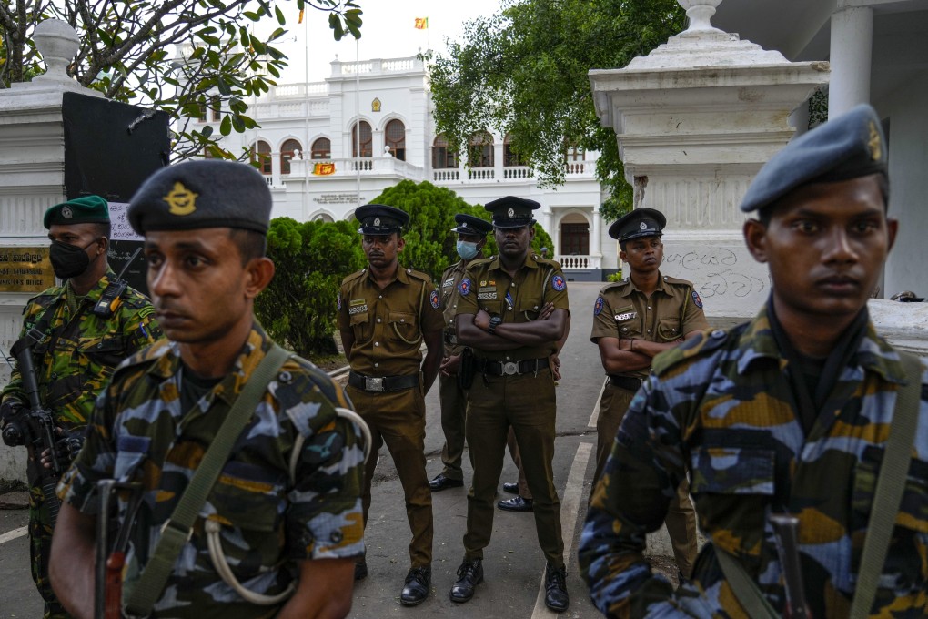 Army and police officers stand guard as protesters leave Ranil Wickremesinghe’s office building in Colombo, Sri Lanka, on Thursday. They had stormed the office hours after he was named acting president. Photo: AP