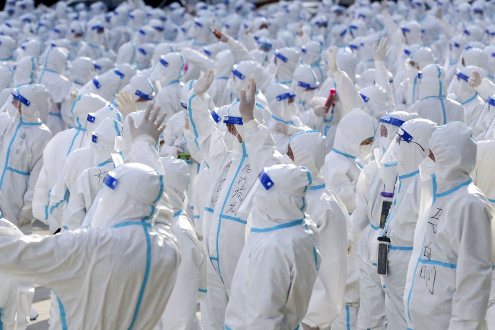 Medical workers who battled a Covid-19 outbreak  in Changchun, the capital of Jilin province, wave at residents during a farewell ceremony before leaving the city in early April. Photo: China Daily via Reuters