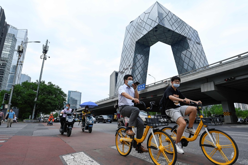 People ride along a street in Beijing’s central business district on July 8. Authorities have been dialling up policy support over the past few months. Photo: AFP