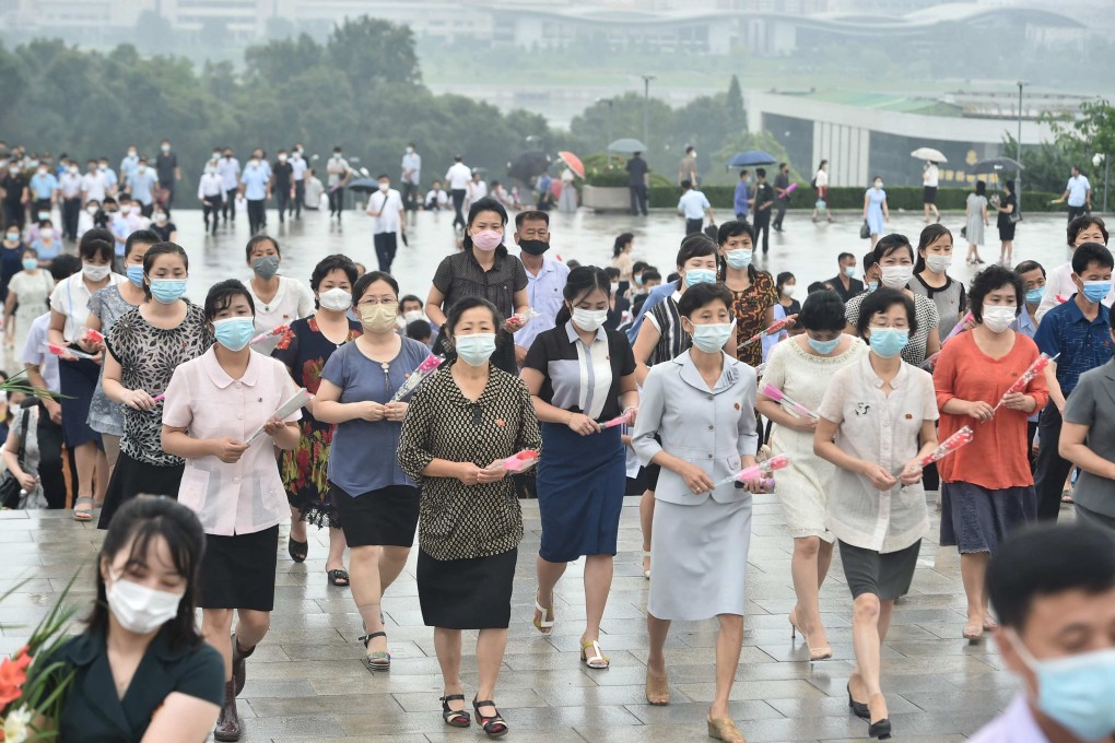 People wearing face masks are pictured in Pyongyang earlier this month as they lay flowers and pay their respects on the 28th anniversary of Kim Il-sung’s death. Photo: AFP