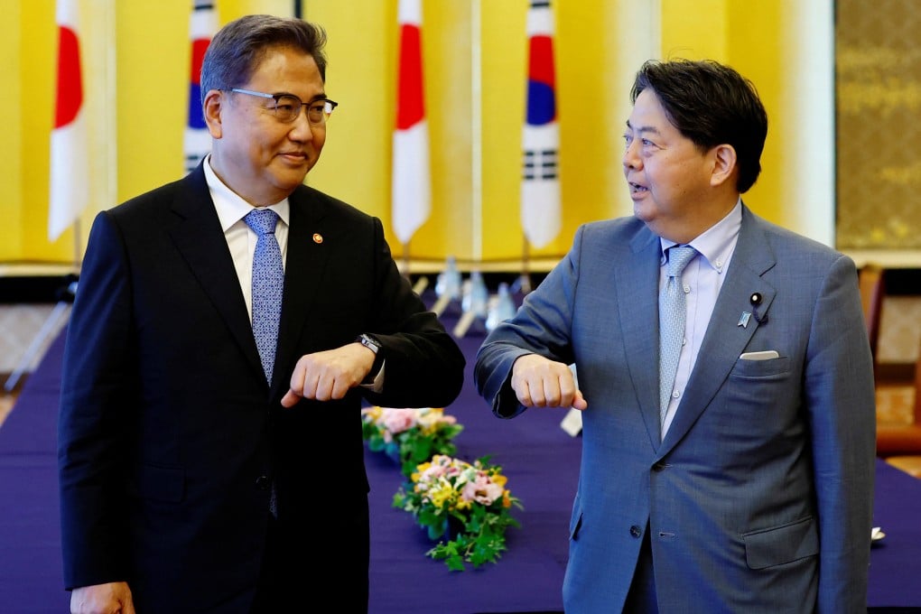 South Korean Foreign Minister Park Jin, left, bumps elbows with his Japanese counterpart Yoshimasa Hayashi before their talks in Tokyo on Monday. Photo: Reuters