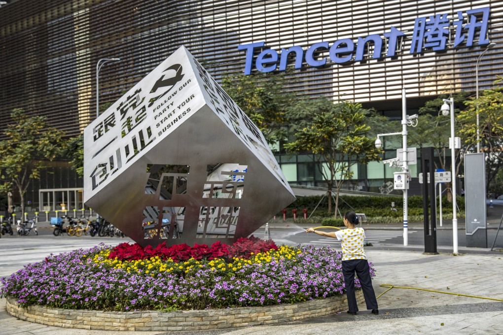 A worker waters the flowers around an installation reading “Follow Our Party Start Your Business” in front of the Tencent headquarters in Shenzhen in March 2021. Photo: Bloomberg