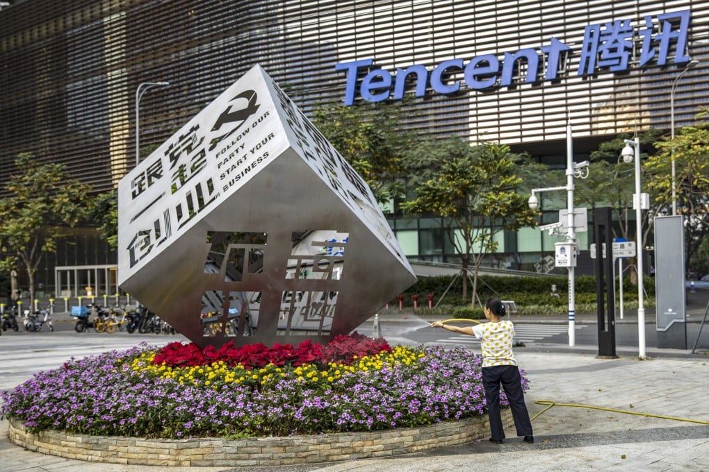 A worker waters the flowers around an installation reading “Follow Our Party Start Your Business” in front of the Tencent headquarters in Shenzhen in March 2021. Photo: Bloomberg