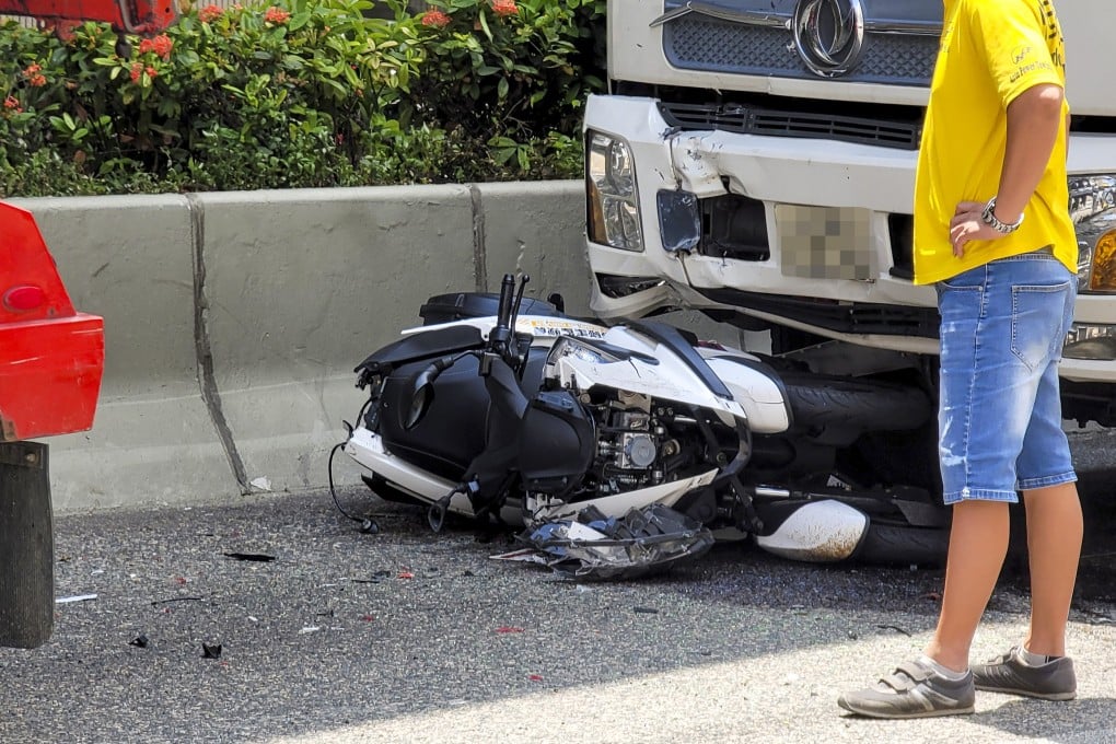 A motorcycle is trapped under a truck that crashed into the back of it and slammed it into a delivery van. Photo: Handout