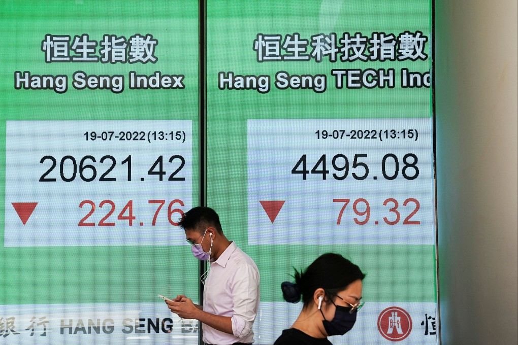 People walk past a screen displaying the Hang Seng Index in Central, Hong Kong on July 19. Photo: Reuters