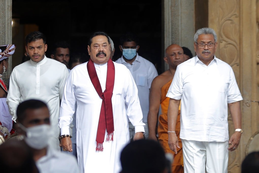 Sri Lanka’s former president Mahinda Rajapaksa (centre) with his younger brother, the recently ousted president Gotabaya Rajapaksa (right), at the Kelaniya Royal Buddhist temple in Colombo on August 9, 2020. Photo: AP