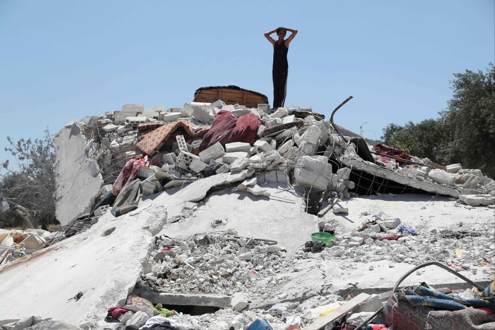 A boy surveys debris following a Russian air strike on the outskirts of the rebel-held city of Jisr al-Shughur in Syria. Photo: AFP