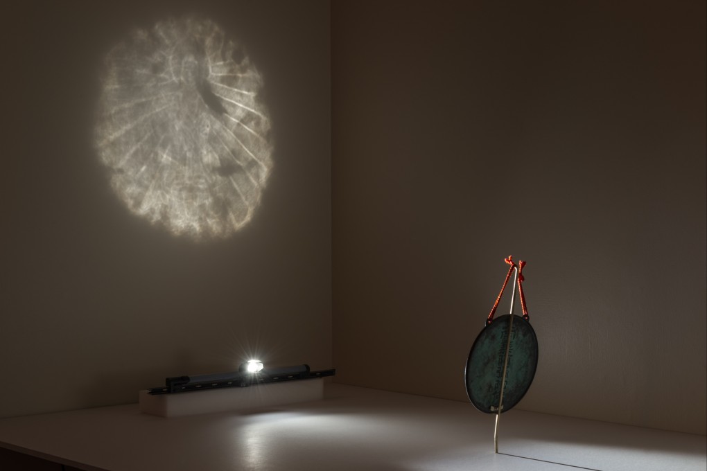 A magic mirror projects an image of a buddha through subtle carvings. Photograph: Rob Deslongchamps