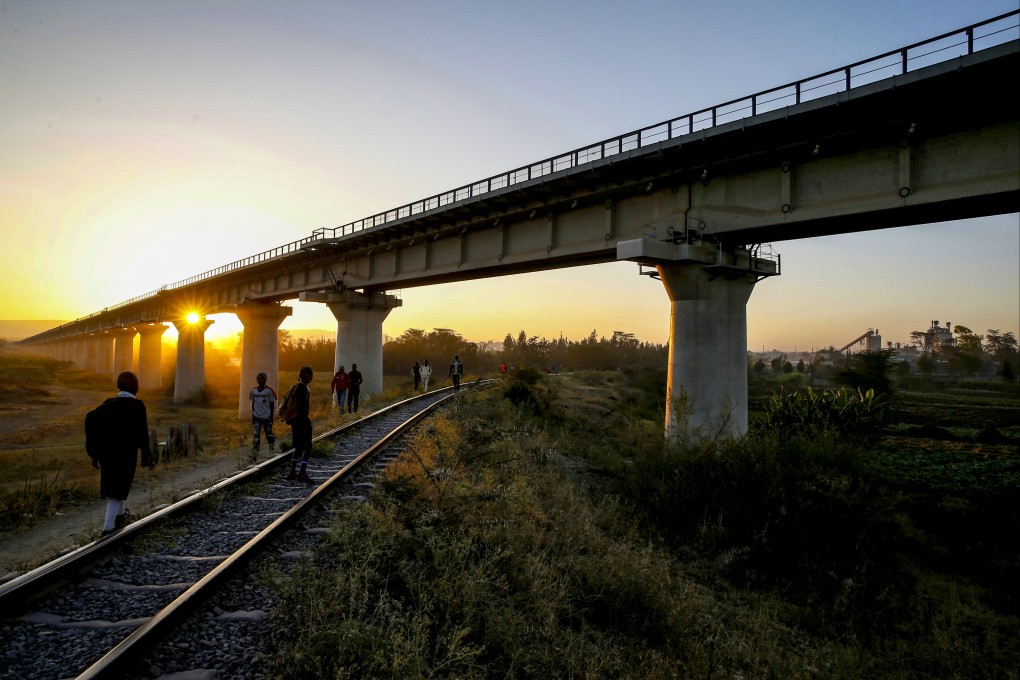 People walk along tracks under a bridge built for the US$4.7 billion Kenyan railway running from the Port of Mombasa to the capital, Nairobi. Photo: Reuters
