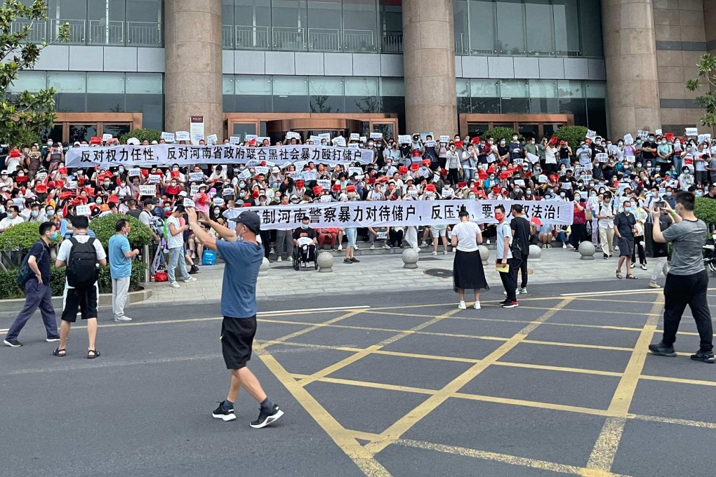 People protest in front of a branch of the People’s Bank of China in Zhengzhou, Henan province, on July 10. Hundreds marched in protest against alleged corruption by local officials in a rare public demonstration. Photo: AFP