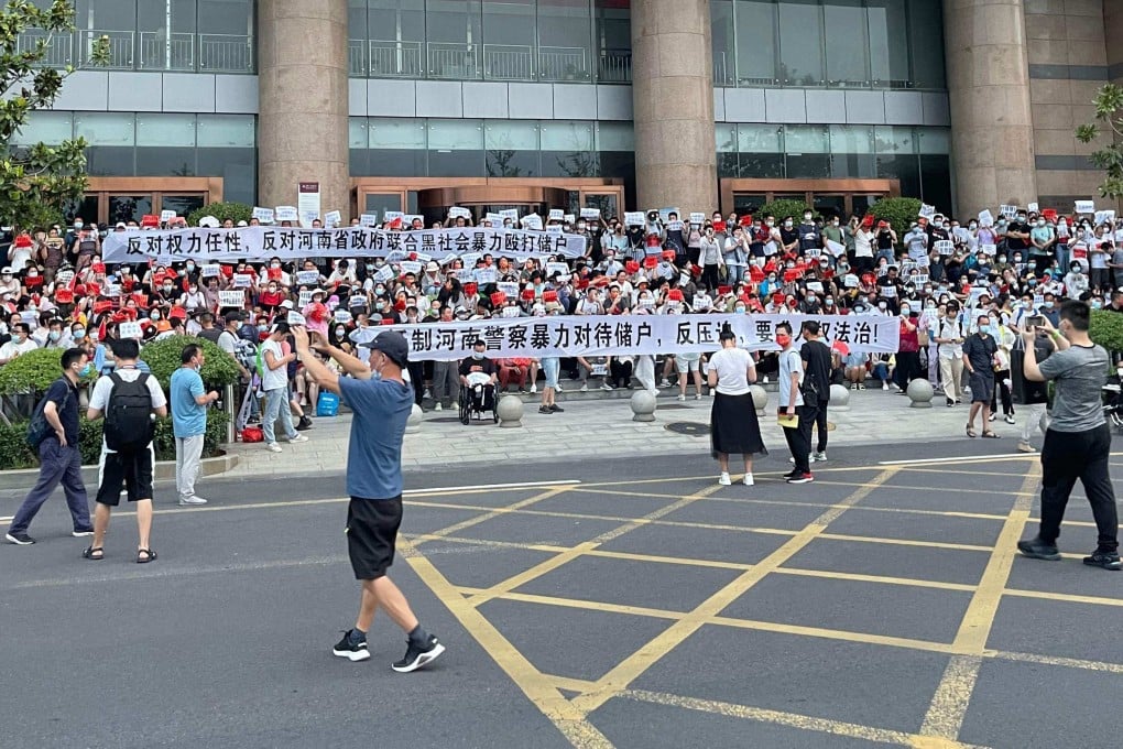 People protest in front of a branch of the People’s Bank of China in Zhengzhou, Henan province, on July 10. Hundreds marched in protest against alleged corruption by local officials in a rare public demonstration. Photo: AFP
