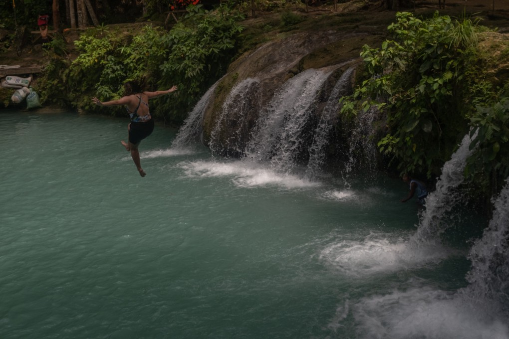 A woman jumps from the Cambugahay Falls, a popular tourist spot, in Siquijor, a Philippine Island that does not allow the use of plastics. 
Photo: Geela Garcia