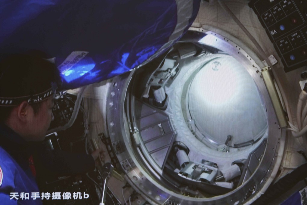 Chen Dong, one of the Tianhe astronauts, opens the hatch of the Wentian lab module after it docked on July 25. Photo: Xinhua via AP