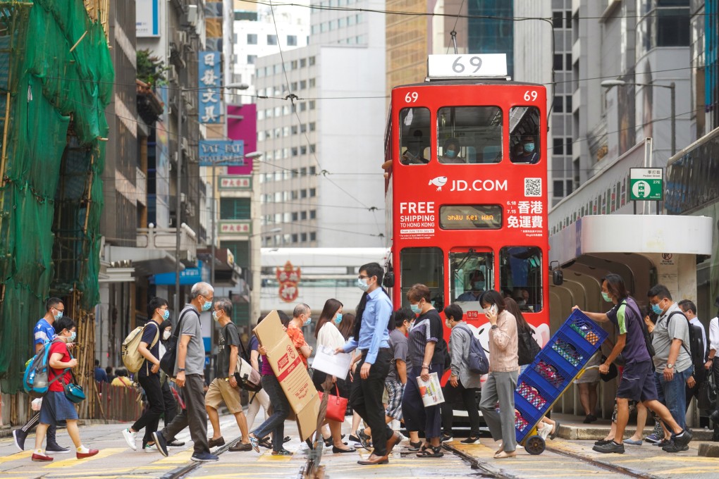 Pedestrians cross the road in Central in 2020. Other than a slogan of “walk more, ride less”, the latest Smart City Blueprint does not have a tangible proposal to reduce private car ownership and attendant pollution. Photo: Winson Wong