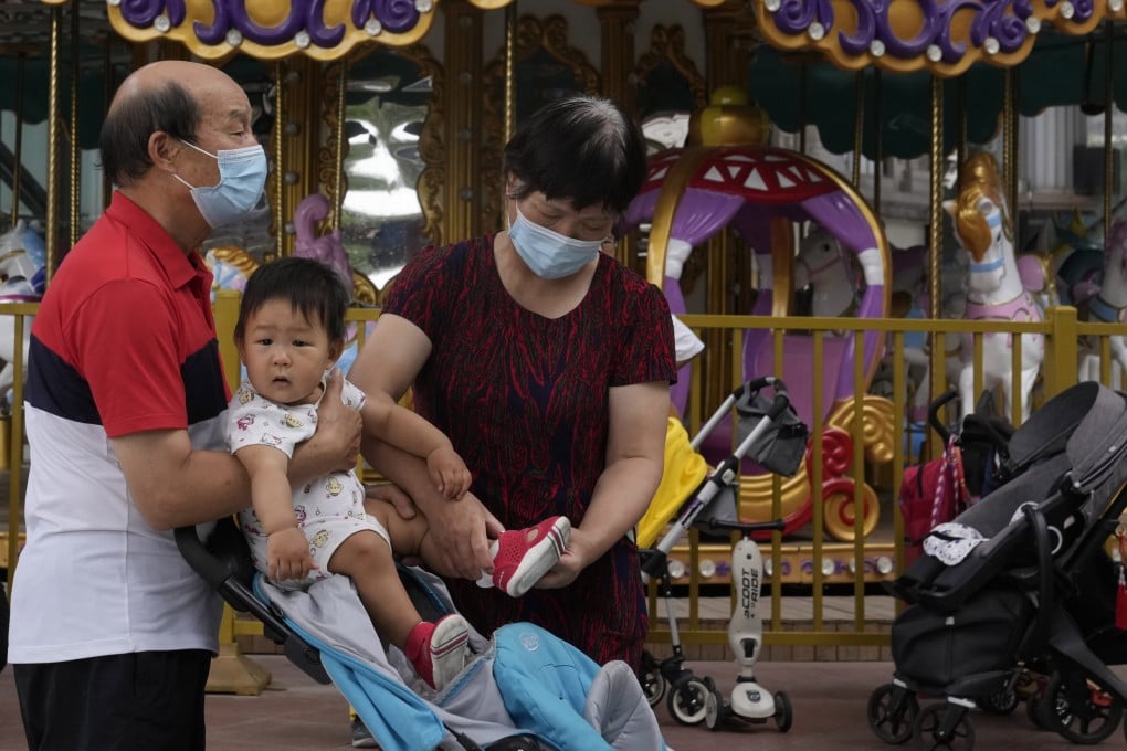 Elderly residents tend to a child near a carousel at a shopping centre in Beijing. Photo: AP