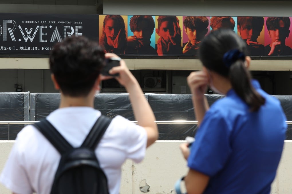 Fans of Canto-pop boy band Mirror take pictures of a billboard featuring the group outside Hong Kong Coliseum. Photo: Yik Yeung -man