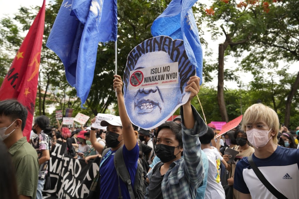An anti-Marcos Jnr protester holds a slogan that reads, “Return what you stole” during a rally in Manila on May 10, 2022. Photo: AP
