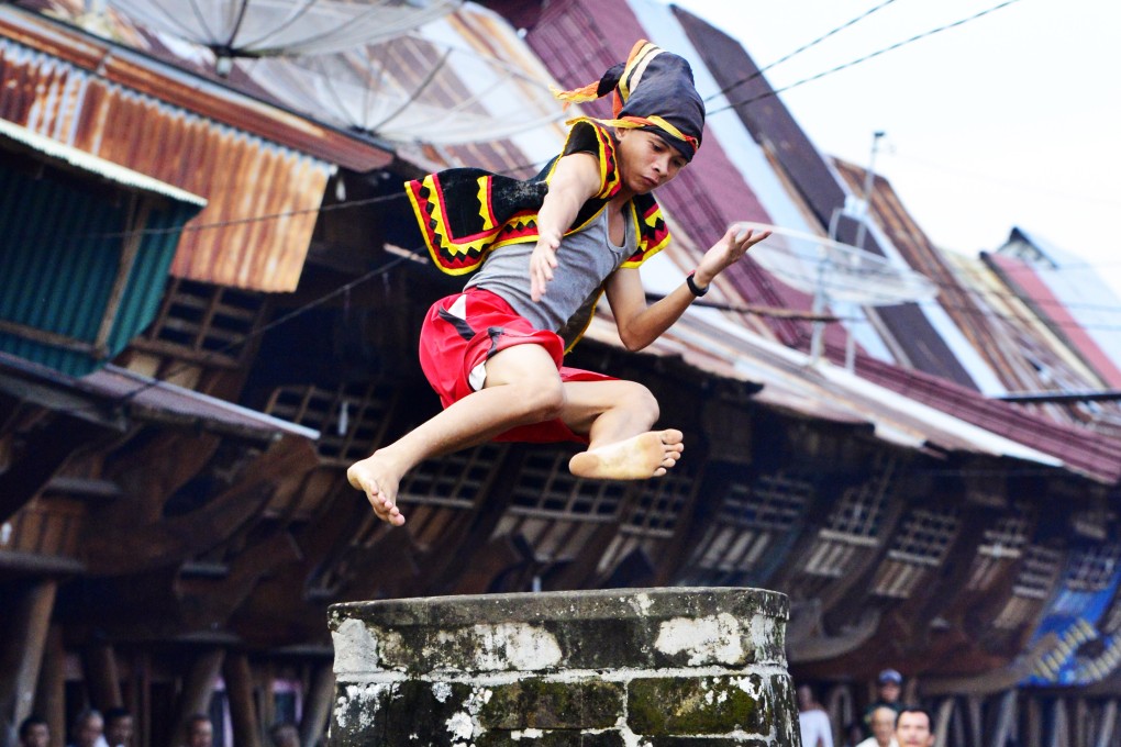 On the Indonesian island of Nias, young villagers jump over a stone pillar two metres tall. It is an example of the wealth of traditional cultures to be found beyond Bali and Java. Photo: Mark Eveleigh