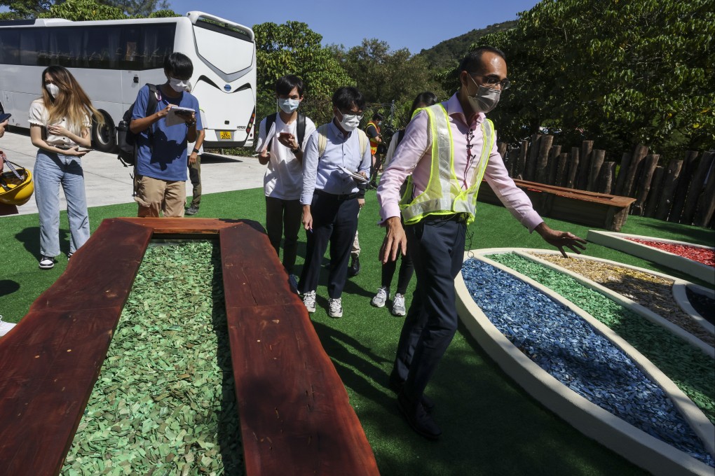 Keith Lai (right), a senior environmental protection officer for the Environmental Protection Department, shows reporters wood chips created by the yard waste recycling centre. Photo: Jonathan Wong