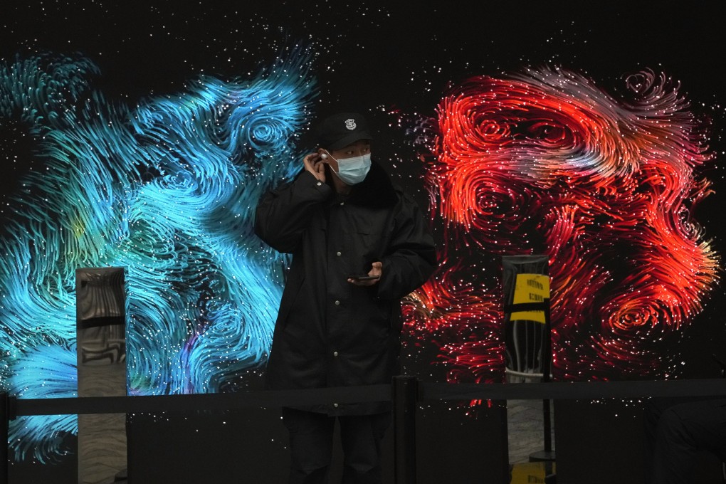 A security guard stands in front of a digital art work displayed outside a mall in Beijing, Nov. 6, 2021. Photo: AP