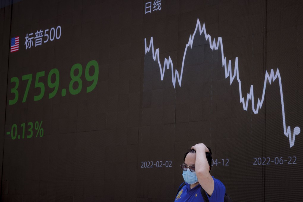A man stands in front of the jumbo screen showing the latest economic and market updates in Shanghai on June 23. Photo: EPA-EFE