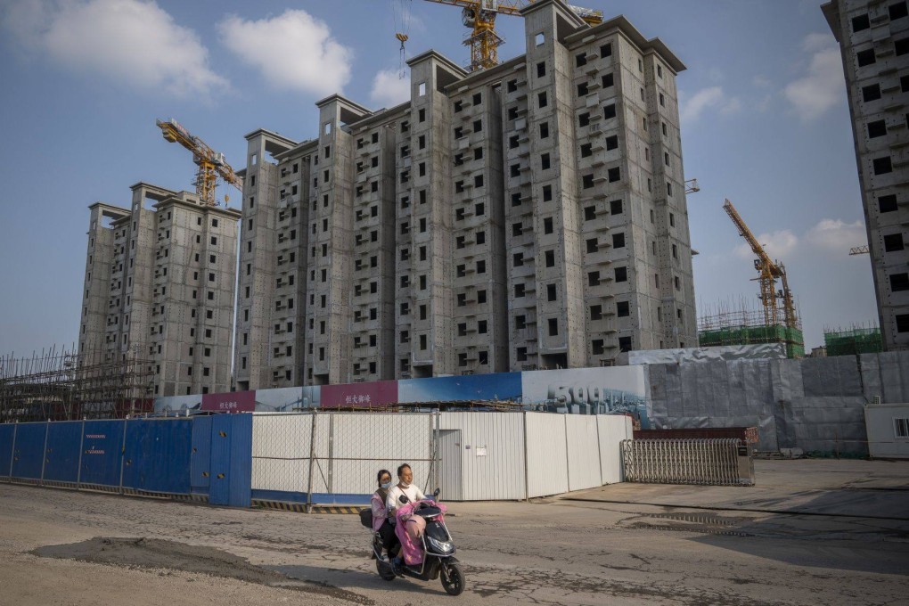 A man and a woman ride past an unfinished China Evergrande residential development in Beijing, on July 29. The war in Ukraine, resurgent inflation and a slowdown in China’s construction sector have all contributed to a volatile first half of 2022 for commodity prices. Photo: Bloomberg