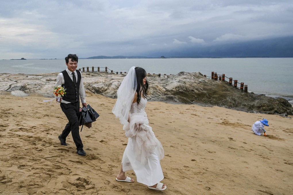 A couple prepare for a wedding photo shoot on the beach in Xiamen, with Taiwan’s Quemoy islands visible in the background. Photo: AFP