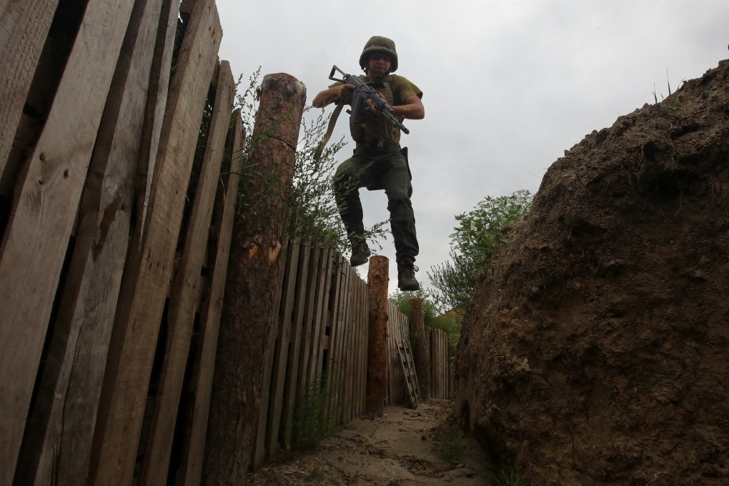 A member of the Ukrainian National Guard jumps into a trench at a position near a front line in Kharkiv region, Ukraine. Photo: Reuters