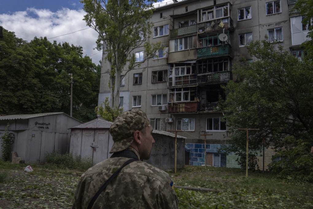 A Ukrainian soldier near flats damaged by a rocket attack on a residential area. Photo: AP