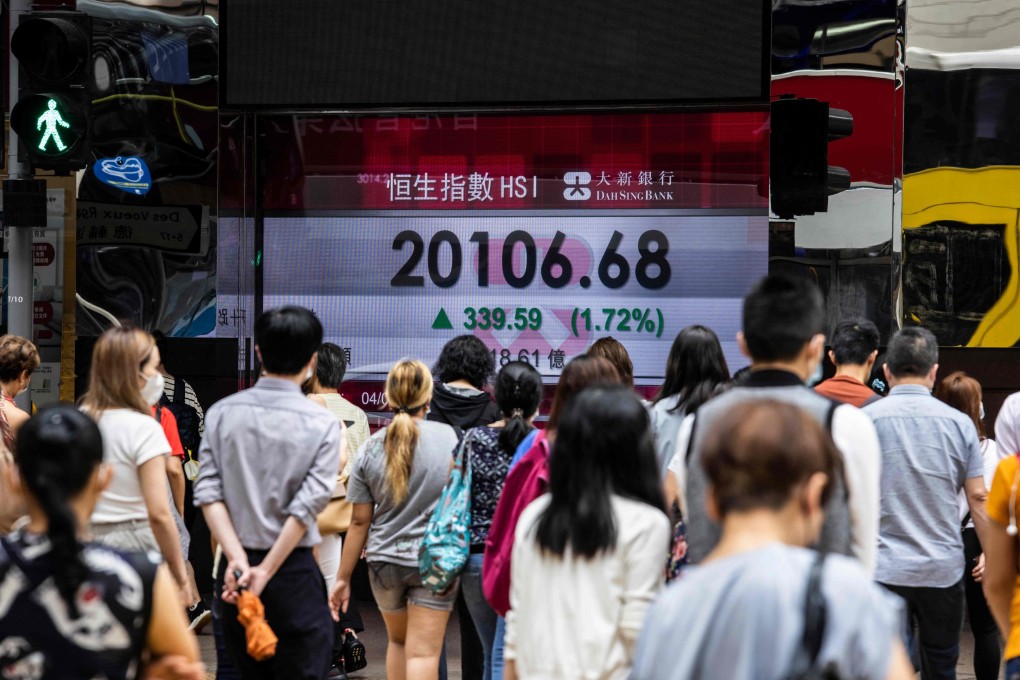 People walk past an electronic display of the Hang Seng Index in Hong Kong on August 4, 2022. Photo: AFP