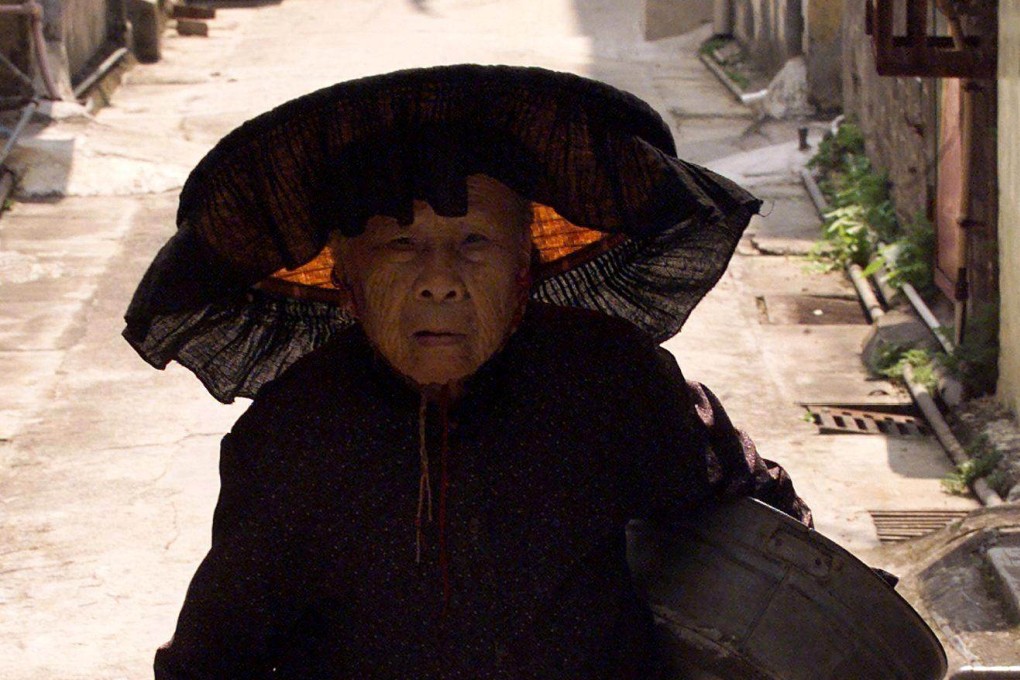 An old Hakka woman wearing a traditional fringed hat walks through the old walled village of Kam Tin in Hong Kong’s New Territories. Han Chinese whose name means “guest people”, the Hakka were refugees for centuries in their own country. Photo: AFP