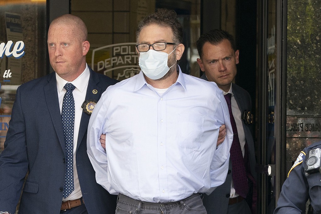 Glenn Hirsch is walked from the New York Police Department 112th Precinct station house in New York in June. Photo: New York Daily News/TNS