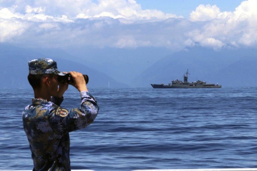 A People’s Liberation Army soldier looks on during military exercises in and over waters around Taiwan on August 5. A Taiwan frigate is seen in the background. Photo: Xinhua via AP
