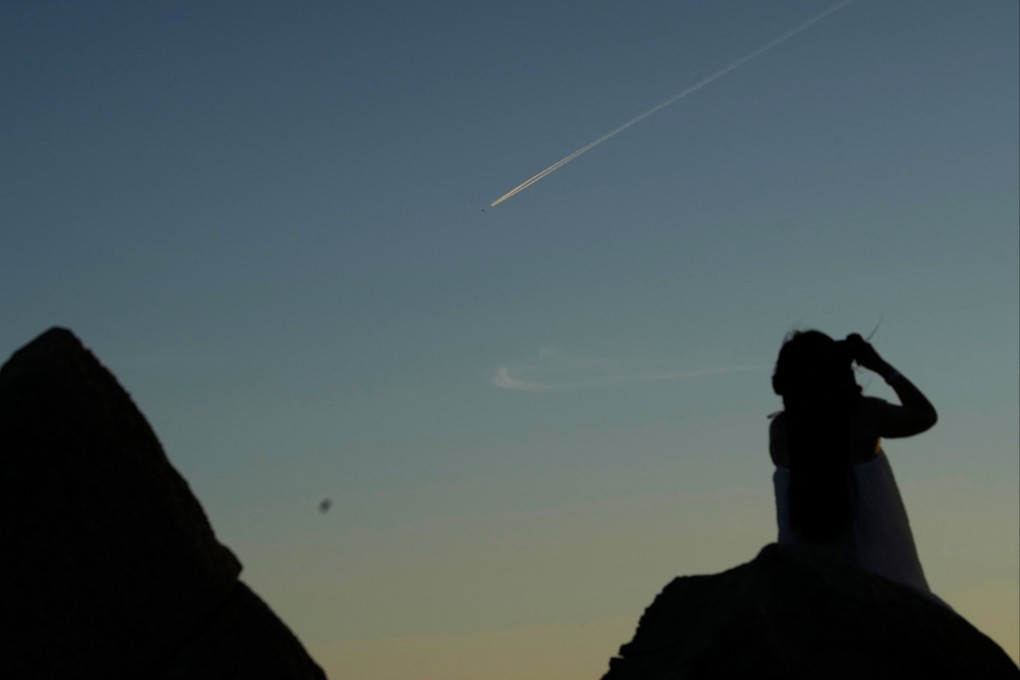 A woman looks at a Chinese People’s Liberation Army aircraft flying over Pingtan island, one of mainland China’s closest points to Taiwan, on August 5. Photo: Reuters