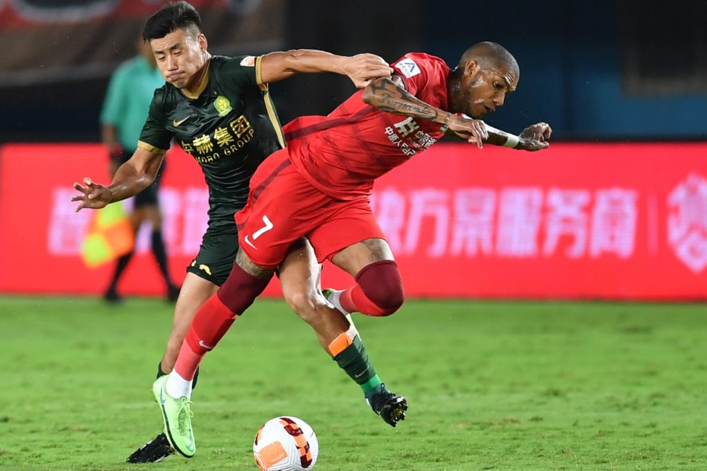 Fernando Karanga (right) of Henan vies for the ball with Zhang Chengdong of Beijing Guoan. Photo: Xinhua