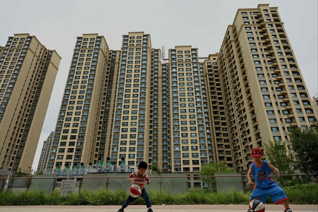 Children play in front of a housing complex by Chinese property developer Evergrande in Beijing on July 28. Photo: AFP