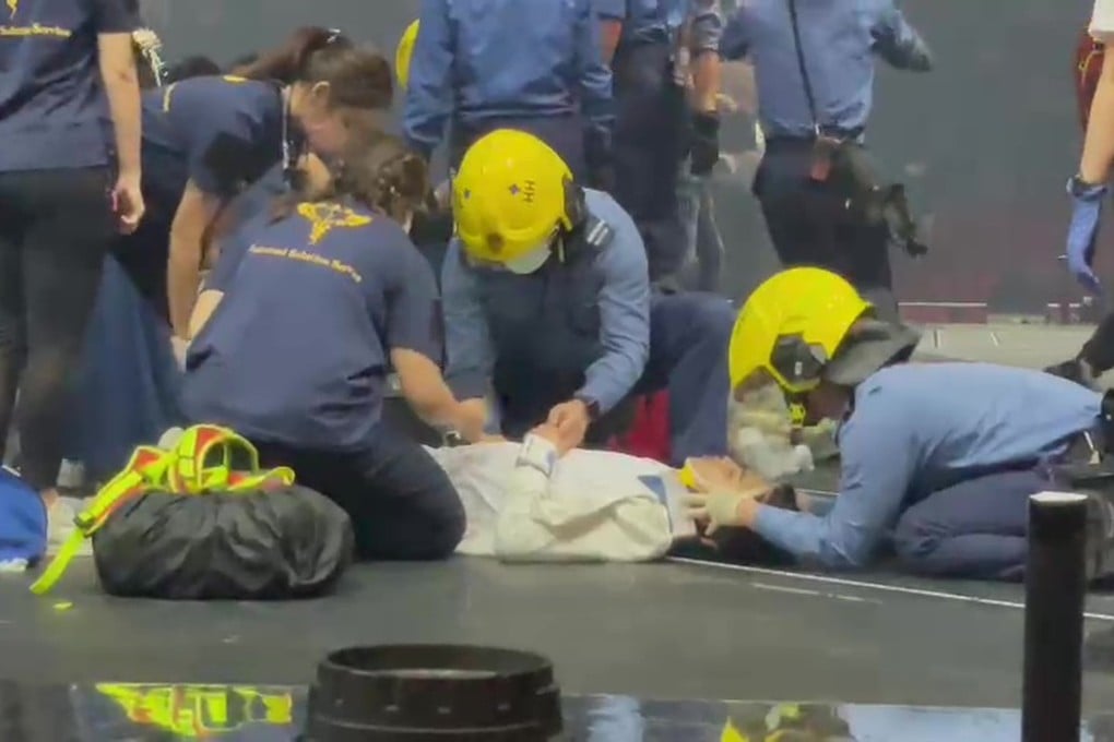 Emergency staff attend to a dancer who suffered a spinal injury when a giant screen fell on him at a Mirror concert in Hong Kong. Spinal injury victims require special handling.