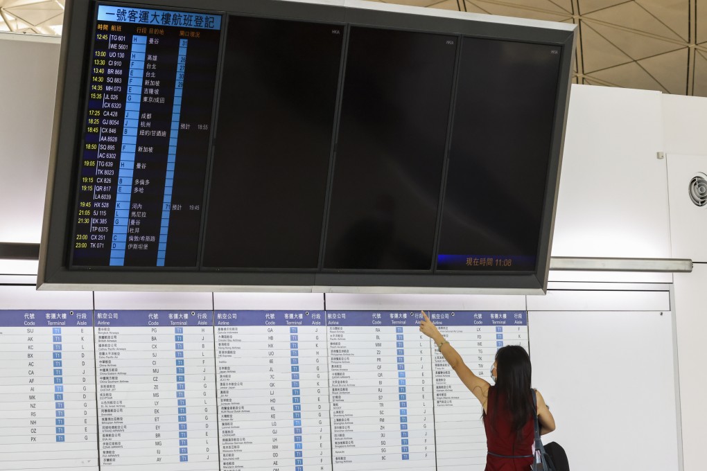 A woman checks departing flight at Hong Kong airport on August 8. Photo: K.Y. Cheng