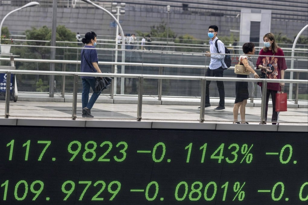 People walk over a pedestrian bridge that features a monitor for stock exchange values in Shanghai in July 2020. Photo: EPA-EFE