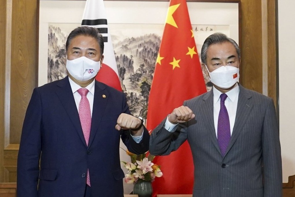 South Korean Foreign Minister Park Jin (left) bumps elbows with his Chinese counterpart Wang Yi before their meeting in Qingdao, China on Tuesday. Photo: South Korea Foreign Ministry via AP