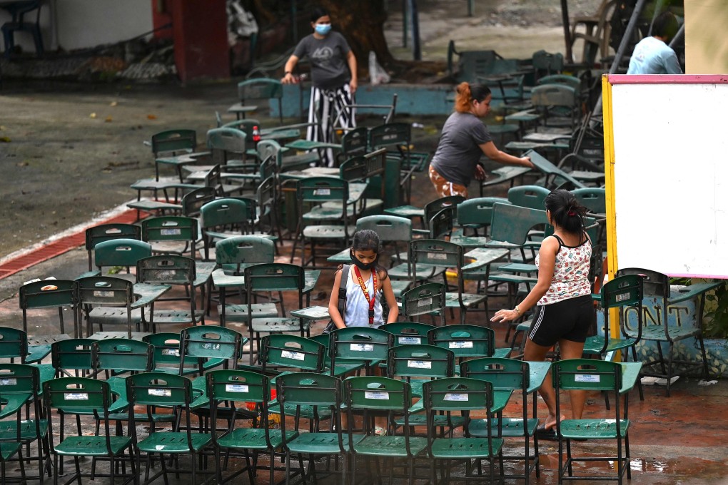 Volunteers scrub chairs as they clean classrooms at a school in Manila, Philippines, on August 5. Photo: AFP