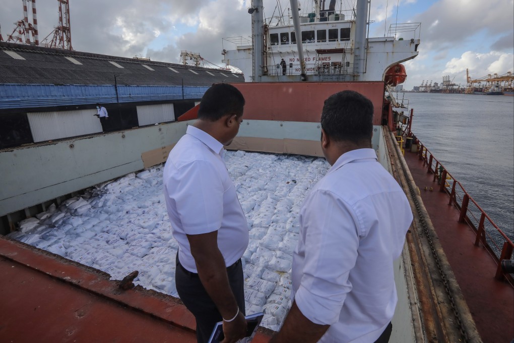 Sri Lankan port officials watch a ship carrying a consignment of humanitarian aid donated by the Indian government to the Sri Lankan people at the port in Colombo. Photo: EPA-EFE