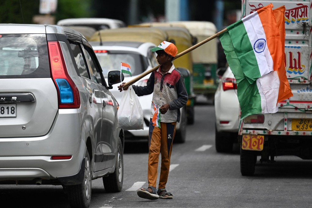 A boy on a New Delhi road sells Indian national flags for the nation’s 75th Independence Day. Photo: AFP