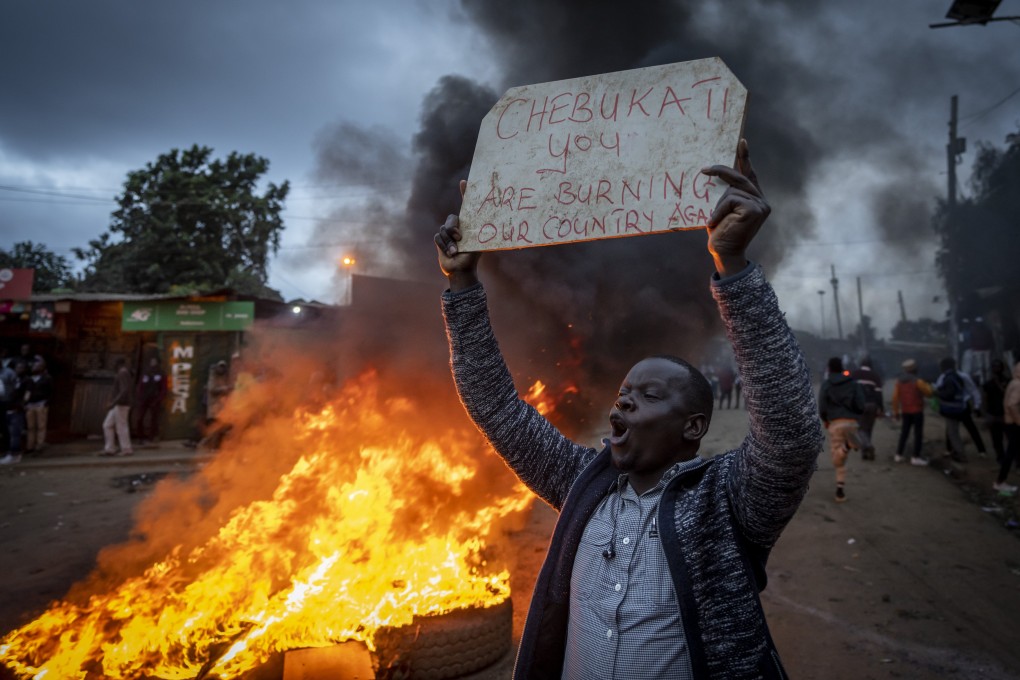 A supporter of presidential candidate Raila Odinga, next to a roadblock of burning tires in the Kibera neighborhood of Nairobi, Kenya. Photo: AP