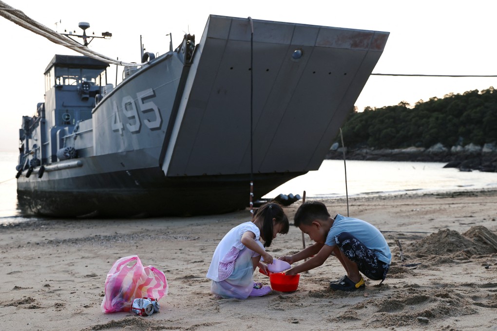 Children play with sand near a Taiwan navy supply ship at a beach on Nangan island of Matsu archipelago on August 16. Photo: Reuters